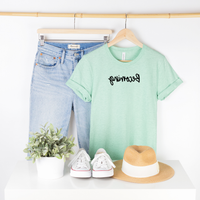 Bella Canvas 3001cvc heather mint t-shirt with Becoming in black script backwards as part of Moxie Momma's Exclusive Reflection line.