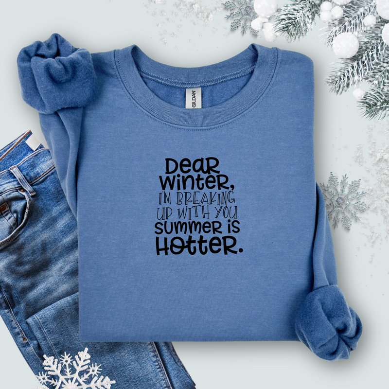 Gildan Indigo Blue sweatshirt with text 'Dear winter, I'm breaking up with you summer is hotter' on a light background with jeans and snowflake decorations.