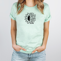 Person wearing a mint green t-shirt with a sunflower graphic and text.