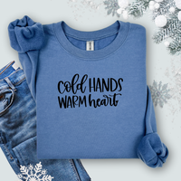 Gildan Indigo Blue sweatshirt with 'Cold Hands Warm Heart' text on a light background with jeans and snowflake decorations.