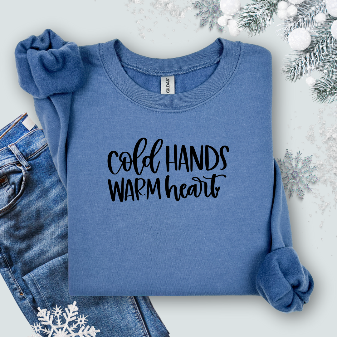 Gildan Indigo Blue sweatshirt with 'Cold Hands Warm Heart' text on a light background with jeans and snowflake decorations.