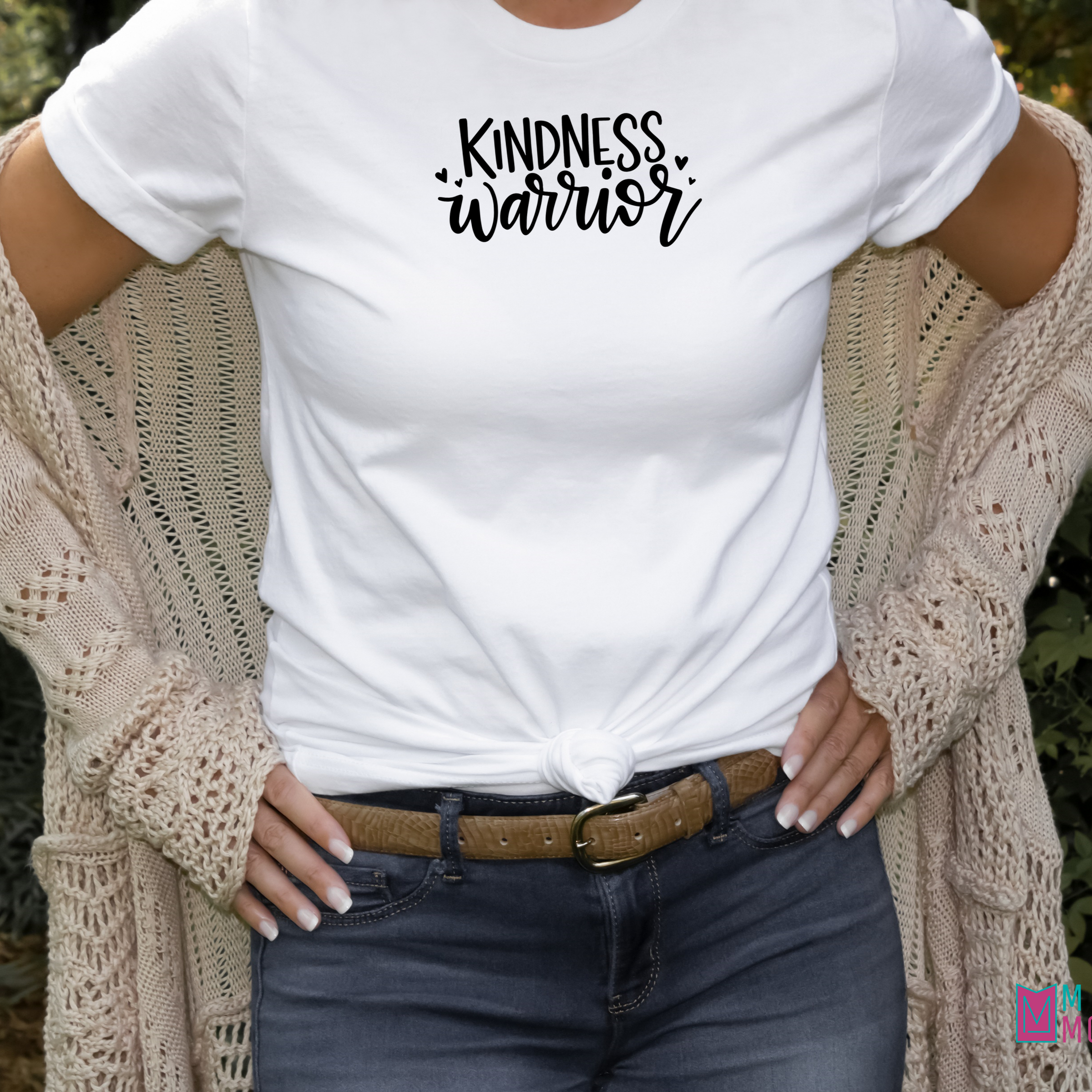 Woman wearing a white bella canvas 3001 t-shirt with black lettering reading Kindness warrior.