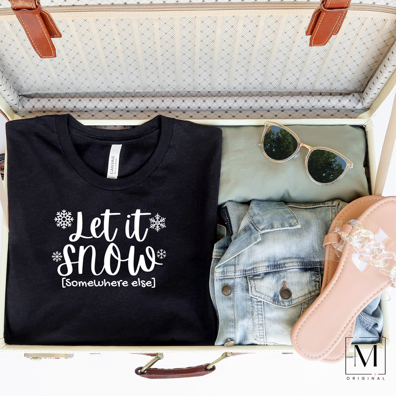 Open suitcase with a Black Heather Bella Canvas tee with snowflakes and Let it snow (in script) [somewhere else] (non-script) in white - Moxie Momma original design
