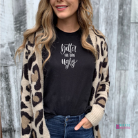 A woman wearing Bella Canvas 3001cvc Black Heather  t-shirt with hand-lettered script text reading better late than ugly in white.
