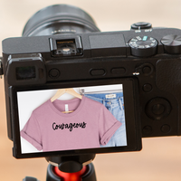 A camera with screen displaying the item as a reflection with the text reading Courageous.