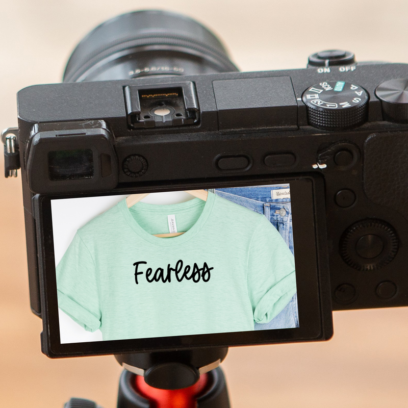 A camera with screen displaying the item as a reflection with the text reading Fearless.