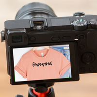 A camera with screen displaying the item as a reflection with the text reading Empowered.
