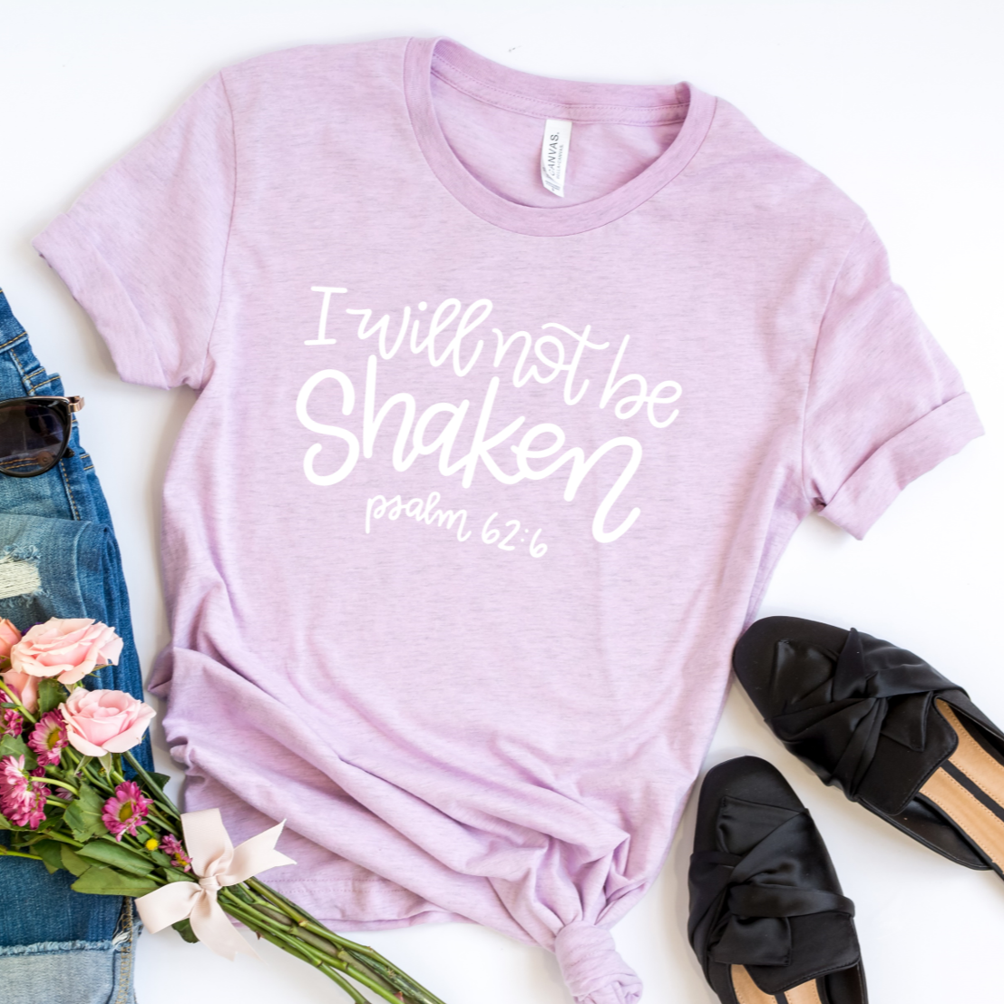 I will not be shaken Psalm 62:6 in white on a heather lilac bella canvas 3001cvc t-shirt.