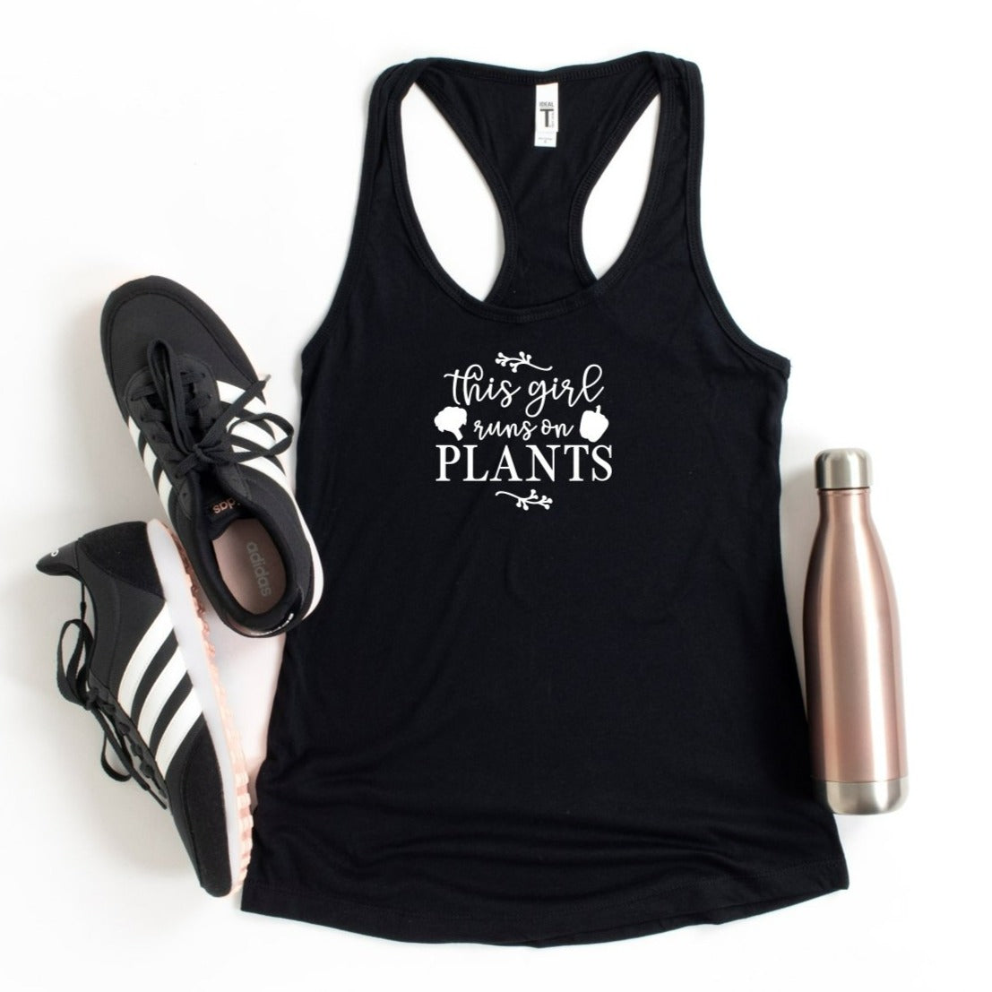 This girl runs on plants in white script on a black Next Level 1533 racerback tank top.